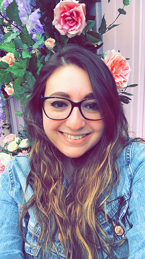 Jessica standing in front of pink and purple flowers